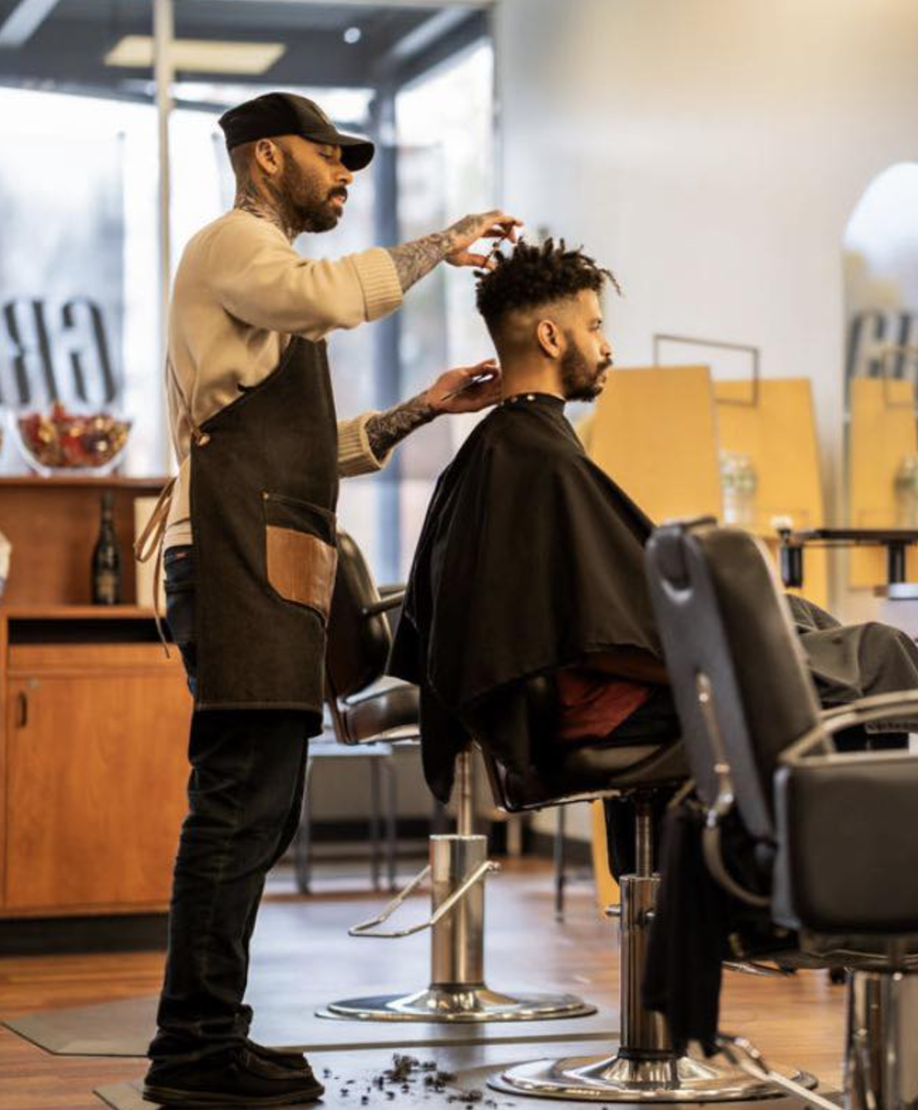 Greg cutting a client's hair in the shop