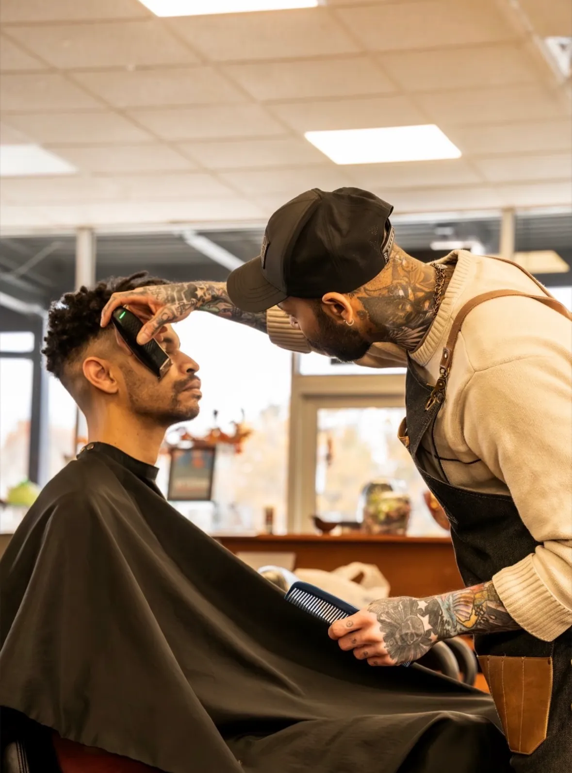 Greg using clippers on a client in the shop