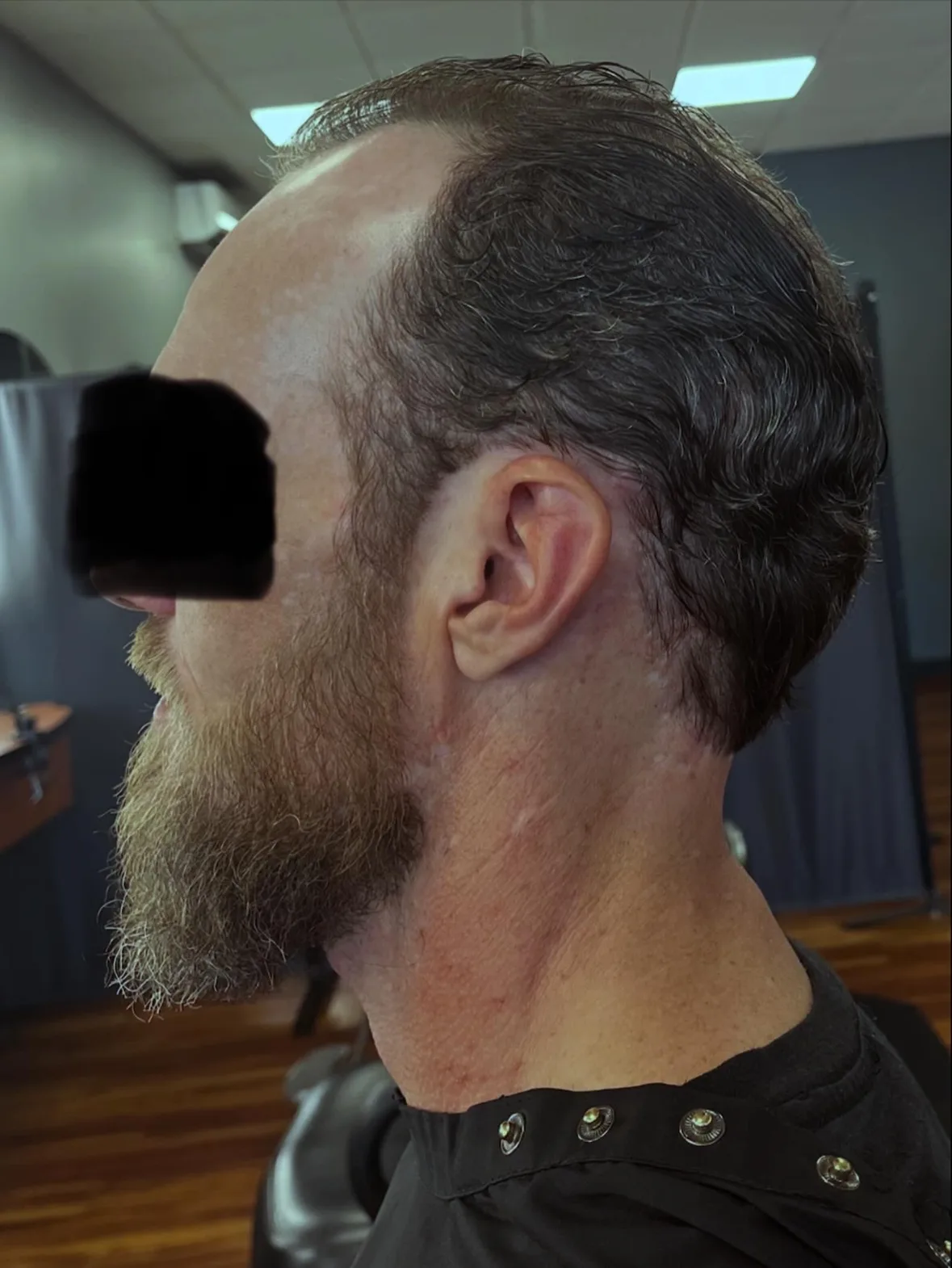 Fresh men's haircut with a neatly trimmed beard in profile