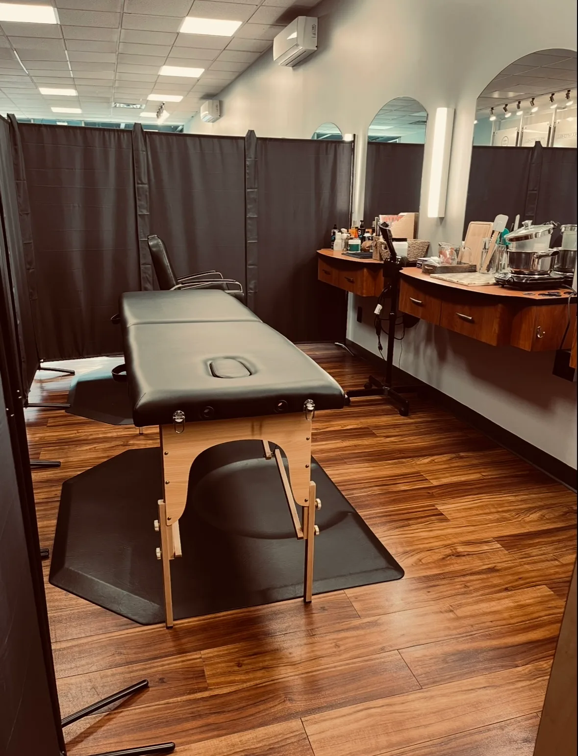 Private treatment cubicle with massage table and curtains